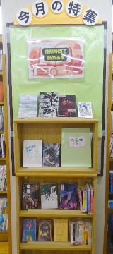 3段の書棚に天板の上も含めて4列分の本が展示されてる写真 3段の書棚に天板の上も含めて4列分の本が展示されてる写真